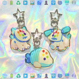 Three pastel-colored acrylic charms shaped like a cat, a dog, and a striped fish, each with a silver star clasp, displayed on a holographic iridescent background.