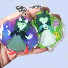 Two colorful character charms held in a hand against a light background