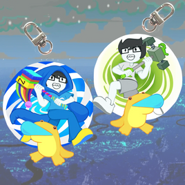 Two circular acrylic keychain charms with metal swivel clips, featuring cartoon characters sitting on yellow ducklings. The left charm shows a blue-haired character in a blue hoodie on a blue-and-white striped background with a rainbow.